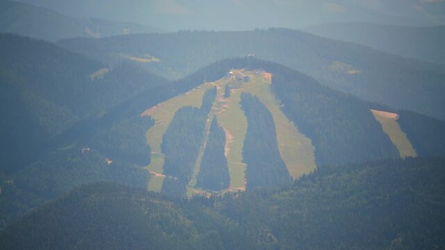 This shows an aerial view of a landscape with fields and mountains. Changes are subtle.