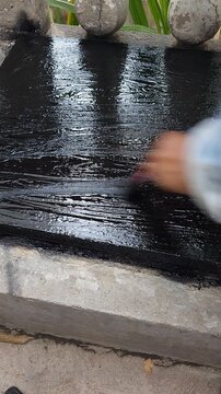 Hand Using Paintbrush to Apply Coating on Metal Cistern Lid