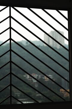 The present artifact is characterized by a contemporary abstract aesthetic, incorporating linear and striped motifs alongside the structural configuration of a window grille for ornamental purposes.