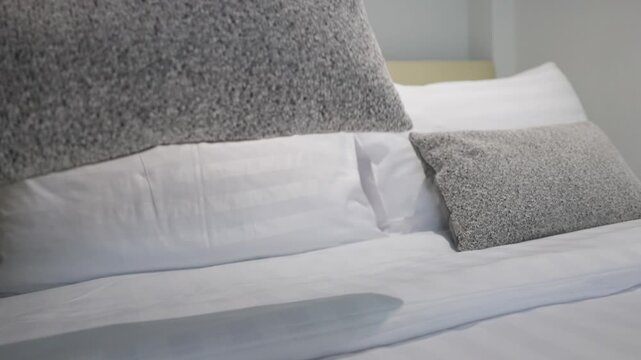 Hotel Housekeeper Making Bed and Arranging Pillows in Bedroom