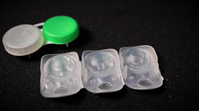 Contact Lens Case and Blister Packs on Black Background