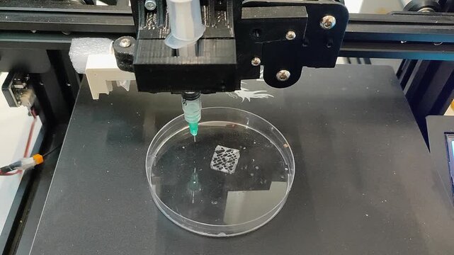 Bio 3D printer. A small bio 3D printer printed a small sample from hydrogel on a work surface. High-tech robotic device for layer-by-layer creation. New modern additive manufacturing. 3D printing