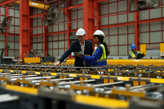 Engineers and staff are inspecting the assembly line system in a metal sheet and metal roofing manufacturing plant.