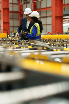 Engineers and staff are inspecting the assembly line system in a metal sheet and metal roofing manufacturing plant.