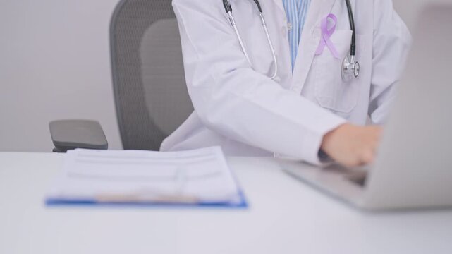 doctor using laptop and report notes on notebook. light purple ribbon for concept of All cancer, April Esophageal Cancer, November gastric and Stomach cancer,  Hodgkin Lymphoma and World cancer day