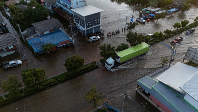 An elevated view of a flooded road with vehicles driving through the water.	