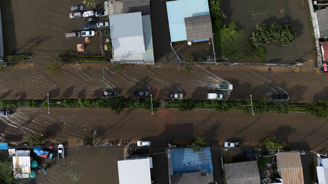 An elevated view of a flooded road with vehicles driving through the water.	