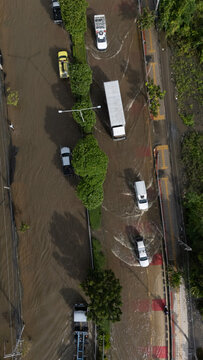 An elevated view of a flooded road with vehicles driving through the water.	