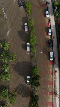 An elevated view of a flooded road with vehicles driving through the water.	