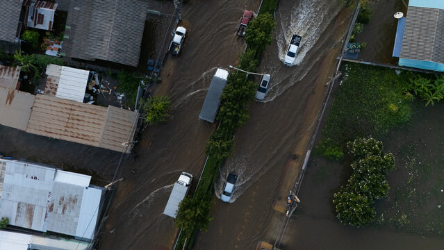 An elevated view of a flooded road with vehicles driving through the water.	