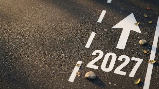The year 2027 painted on an asphalt road with a white arrow pointing forward, symbolizing future goals, planning, and moving ahead in life or business