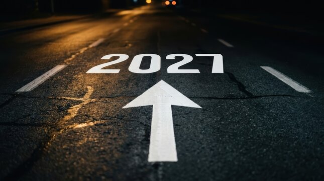 Road surface with the year 2027 painted in white and a directional arrow pointing forward, symbolizing future goals, planning, and progress