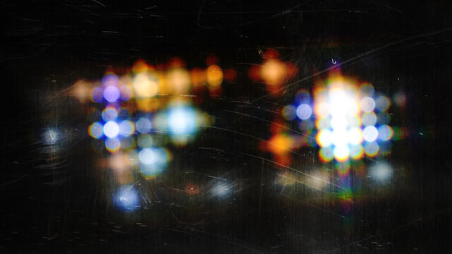 Vintage lens flare texture, retro light leak on dark background, scratched film overlay with bokeh effects