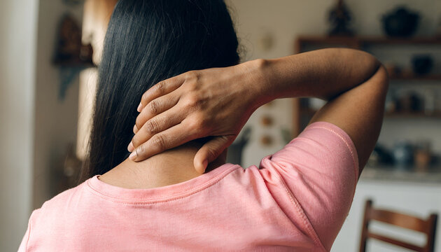 Woman Experiencing Neck Pain and Muscle Tension at Home