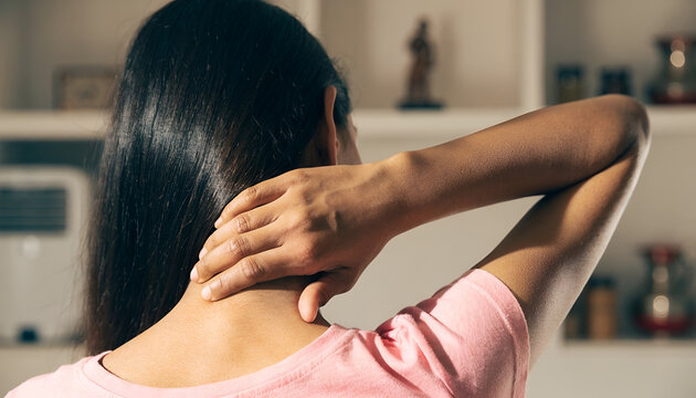 Woman Experiencing Neck Pain and Muscle Tension at Home