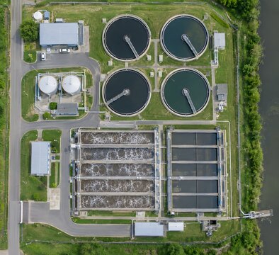 Wastewater treatment plant aerial view with circular settling tanks and aeration basins