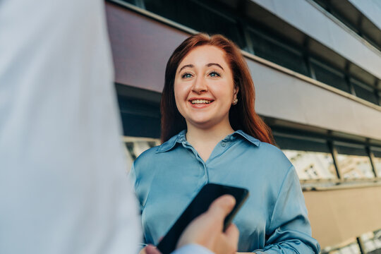 Female manager or employee talking with business colleague, stylish suit, outdoor portrait