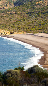 Il golfo di Galeria nella costa occidentale della Corsica con la torre genovese detta Calcinaggia e la spiaggia di sabbia nera della Ricciniccia sulla foce del fiume Fango