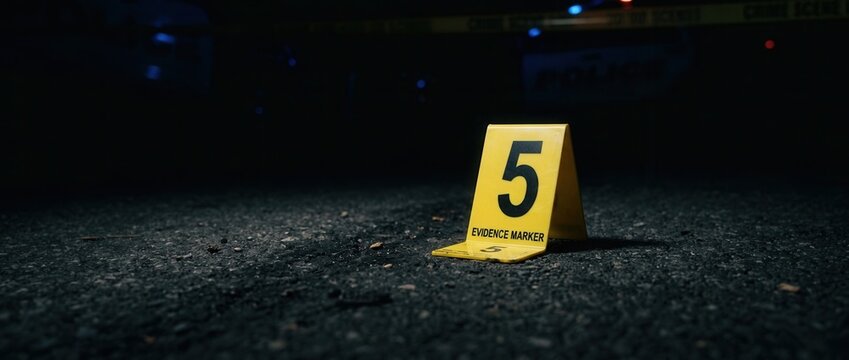 Crime Scene Evidence Marker Number 5 on Asphalt at Night Police Lights in Background