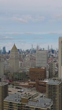 Vertical video: Aerial slider of buildings in Civic Centre. High rise structures in borough with government and municipal. Modern skyscrapers in distance. Manhattan, New York City, USA