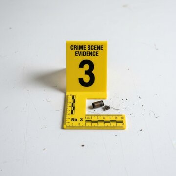 Crime scene evidence marker 3 with bullet casing and debris on white surface forensic investigation