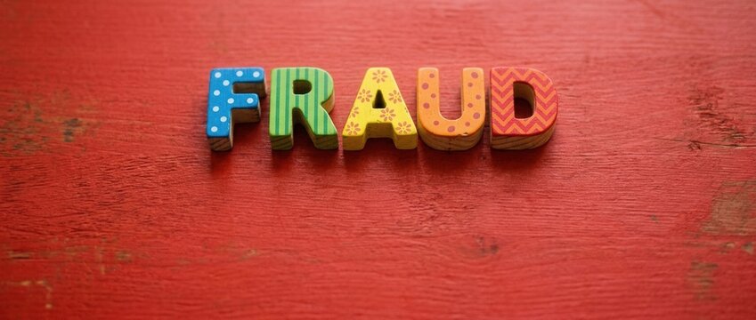 Colorful Wooden Letters Spell Fraud on Rustic Red Textured Background