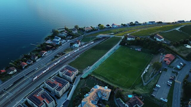High angle drone view of a train passing lakeside near Cully, Switzerland