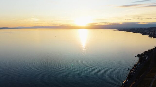 Drone tilts up over Lake Geneva revealing sunset near Cully, Switzerland