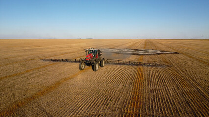Aerial View of Self-Propelled Agricultural Sprayer Treating Stubble Field © Andrey