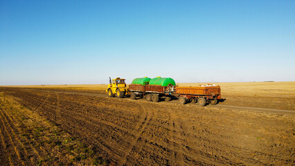 Aerial View of Tractor Towing Liquid Fertilizer Trailers Across Agricultural Fields © Andrey