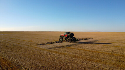 Aerial View of Self-Propelled Agricultural Sprayer Treating Stubble Field © Andrey