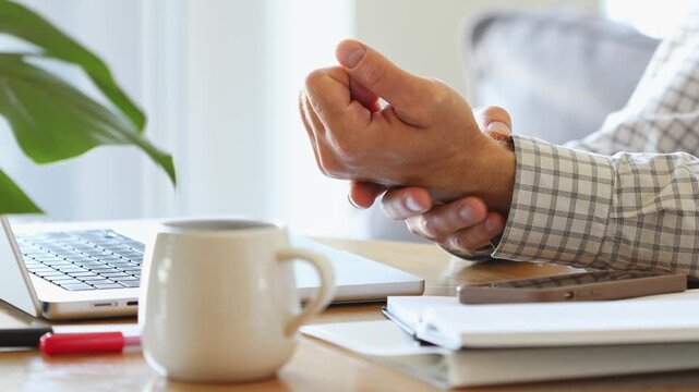Man with inflamed and painful fingers and wrists on hands from joint inflammation, tendon pain and  muscle tension. Health and medical concept of digital wotk lifestyle.