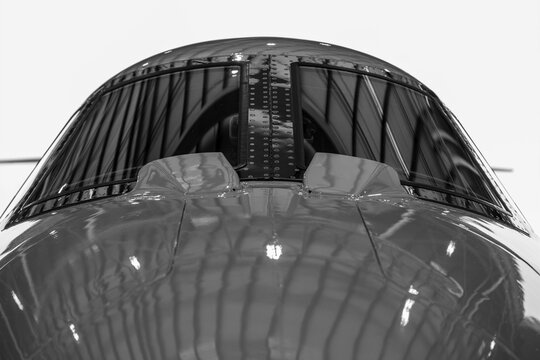Close-up of private airplane cockpit windshield and riveted metal nose structure.