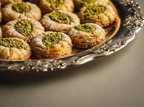 Ma'amoul cookies and pistachio baklava on an engraved silver tray