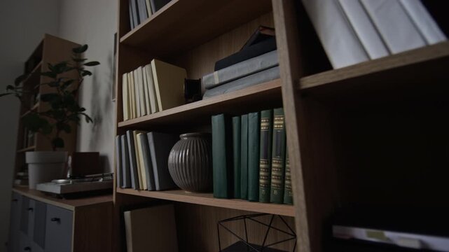 No people shot of wooden shelves with books, notebooks and vase in therapists office. Video suitable for corporate branding, creative studio and interior design concepts