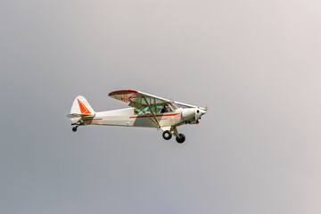 Small single engine propeller aircraft flies against on a gray sky © Lars Johansson