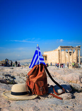 backpack straw hat and greek flag with acropolis erechtheion background in athens greece