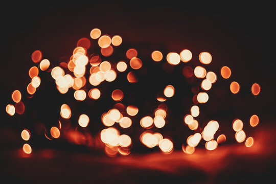 Abstract dark background with glowing golden bokeh lights creating a festive holiday effect