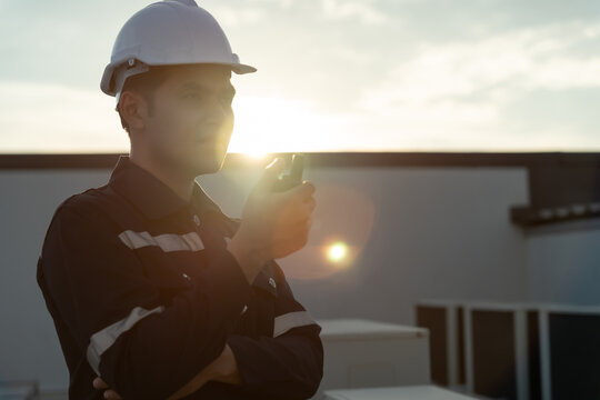 Asian maintenance engineer work on the roof of factory. contractor inspect compressor system and plans installation of air condition systems in construction. technology, walky talky, maintenance