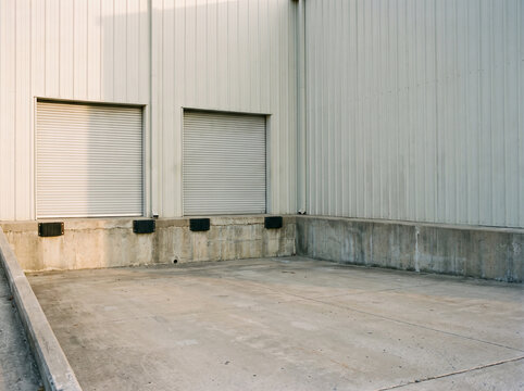Two closed warehouse loading doors above an empty dock