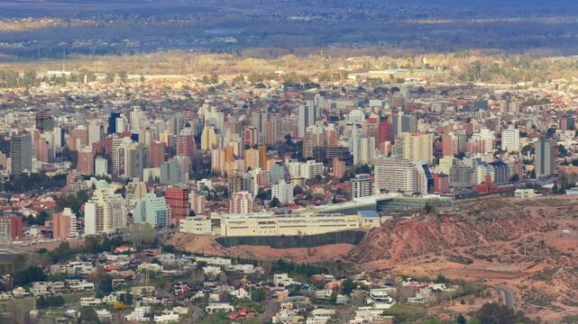 Neuquen city skyline, Alto Comahue Shopping, eroded barda terrain, dense central districts, residential neighborhoods and Patagonian plateau, drone aerial view