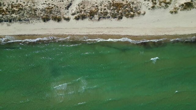 Drone footage capturing the wild and scenic sandy coastline of Flamingo beach with turquoise sea water near Tigkaki village on Kos island, Greece.