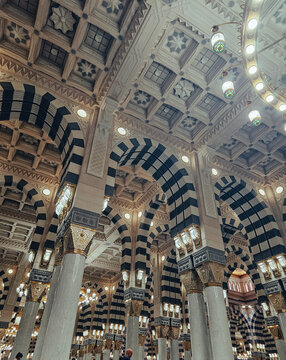 Low angle view of ornate ceiling decorated arches and marble columns inside Prophet Mosque in Medina