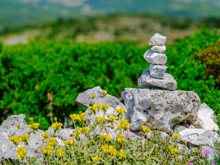 Steinmännchen zur Orientierung auf Felsen vor grüner Landschaft in Griechenland © Thomas Hut
