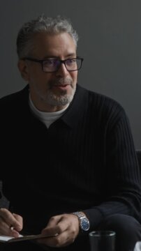 Vertical shot of middle aged Caucasian therapist writing notes and talking during therapy consultation. Footage suitable for mental health campaigns and medical counseling promos