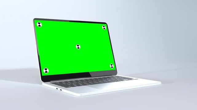 Silver laptop with green screen and tracking markers on white background, slow low angle camera orbit