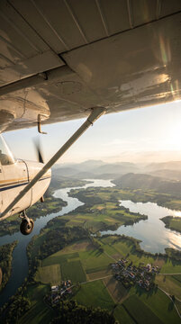 Small General Aviation Aircraft Flying Over Mountains at Golden Hour