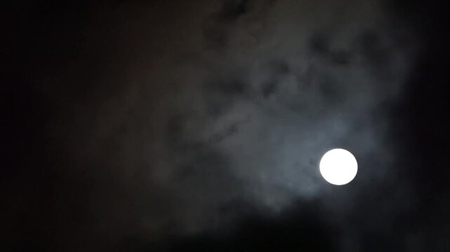 暗い夜空を漂う雲と不気味に浮かぶ月