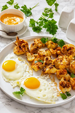 Fried eggs and roasted cauliflower on a plate