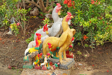 Colorful Rooster Statues and Figurines in Thai Garden Shrine © blueringmedia